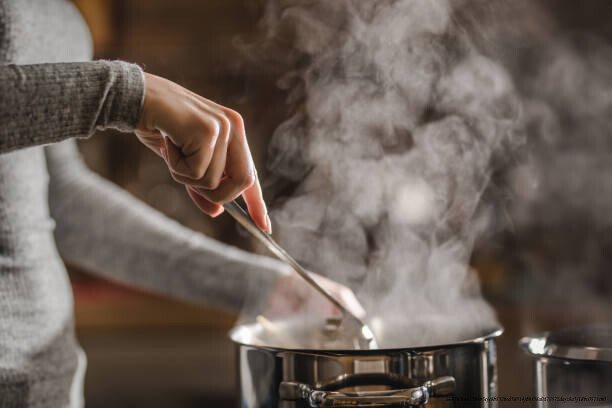 MEAL PREP : GAIN DE TEMPS ET ÉCONOMIES EN PRÉPARANT SES REPAS LE DIMANCHE 5 Unrecognizable woman stirring soup in a saucepan while making lunch.