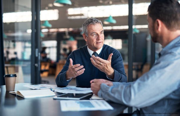 ÉCOUTE ACTIVE : COMMENT AMÉLIORER SES RELATIONS PROFESSIONNELLES 4 Shot of a mature businessman having a discussion with a colleague in an office