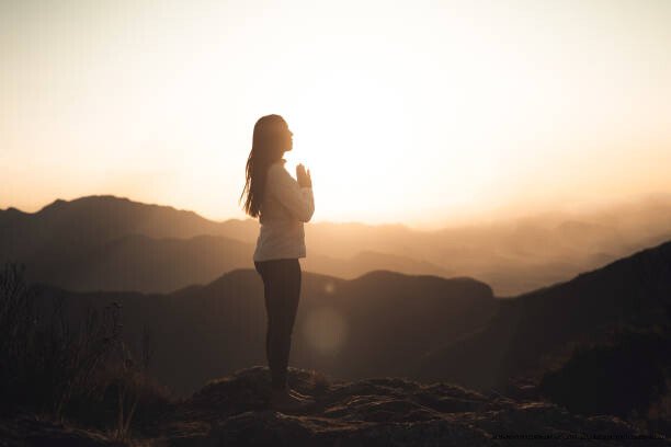 LE POUVOIR DE LA GRATITUDE : CE QUE DIT LA SCIENCE SUR LE BIEN-ÊTRE 5 Woman meditating at sunset in the mountains