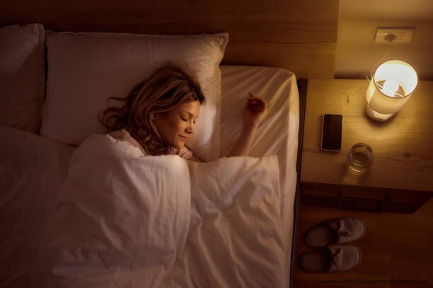COMMENT CONSTRUIRE UNE ROUTINE DE SOMMEIL RÉPARATRICE 3 High angle view of relaxed woman dreaming a nice dream while sleeping in bed.