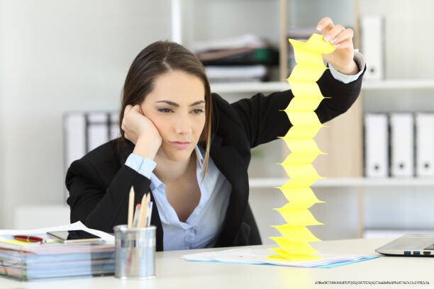 VAINCRE LA PROCRASTINATION : LA RÈGLE DES 2 MINUTES EXPLIQUÉE 5 Bored executive wasting time playing with reminders at office