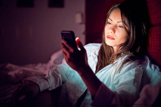 POURQUOI ET COMMENT SORTIR DE LA COURSE À L'AMOUR À TOUT PRIX EN 5 ÉTAPES 4 Woman is texting in bed at night