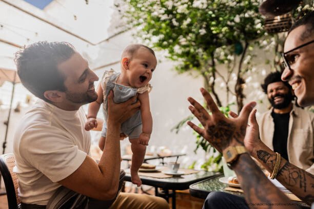 COMMENT LE REGARD DES AUTRES MODIFIE SILENCIEUSEMENT NOTRE COMPORTEMENT QUOTIDIEN 4 Father playing with daughter during friends meeting at coffee shop