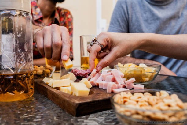 POURQUOI QUITTER SON GROUPE SOCIAL D'ORIGINE EST L'UNE DES CHOSES LES PLUS DIFFICILES À FAIRE 5 Close up of friends eating appetizers during lunch party at home