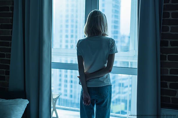 COMMENT RÉSISTER À L'ENVIE DE SE SUICIDER APRÈS UNE DÉCEPTION AMOUREUSE BRUTALE SELON LES EXPERTS EN PSYCHOLOGIE 3 Young woman standing near window