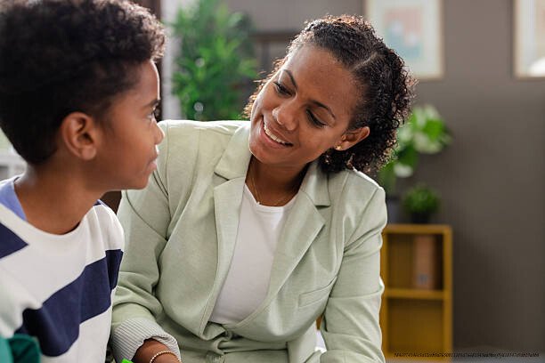 DÉPRESSION : POURQUOI LES GENS QUI SOURIENT LE PLUS SONT SOUVENT LES PLUS TOUCHÉS 4 Smiling therapist listening to young patient during therapy session at office
