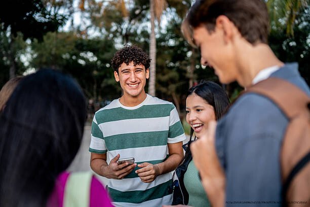 POURQUOI QUITTER SON GROUPE SOCIAL D'ORIGINE EST L'UNE DES CHOSES LES PLUS DIFFICILES À FAIRE 3 Portrait of teenage boy using mobile phone with friends on public park