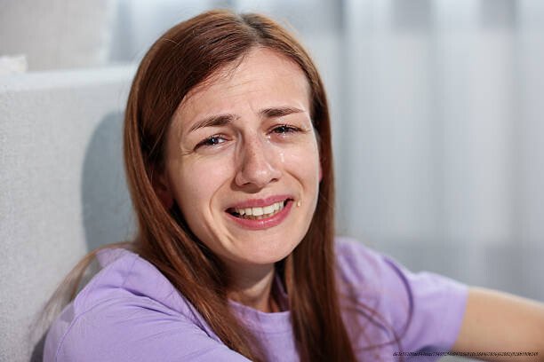 DÉPRESSION : POURQUOI LES GENS QUI SOURIENT LE PLUS SONT SOUVENT LES PLUS TOUCHÉS 5 Beautiful woman laughing through tears indoors, closeup