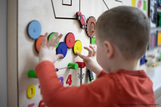 LA DÉCOUVERTE DE L'APPRENTISSAGE CHEZ LES ENFANTS : CE QUE LA SCIENCE NOUS APPREND SUR LE CERVEAU DES TOUT-PETITS 4 Three years old boy playing on the busy board at his psychotherapy session.
