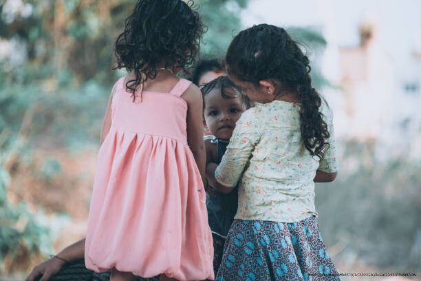 SÉQUELLES INVISIBLES DES ORPHELINS ET DES ENFANTS ABANDONNÉS 6 mother playing with baby boy and baby girl in front of their home