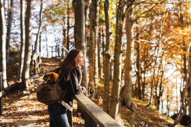 LES BIENFAITS DE LA NATURE SUR LA SANTÉ MENTALE 3 Hiker young woman enjoying the autumn forest