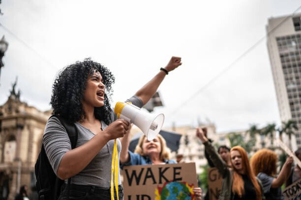 LES INÉGALITÉS DE JUGEMENT : POURQUOI LES FEMMES SONT-ELLES ÉVALUÉES DIFFÉREMMENT DES HOMMES POUR LES MÊME CRIMES 6 Young woman leading a demonstration using a megaphone