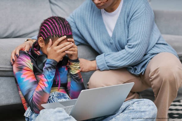 COMMENT COMPRENDRE ET PRÉVENIR LE CYBERHARCELEMENT CHEZ LES ADOLESCENTS 3 Portrait of depressed teenage girl crying on floor with mother comforting her