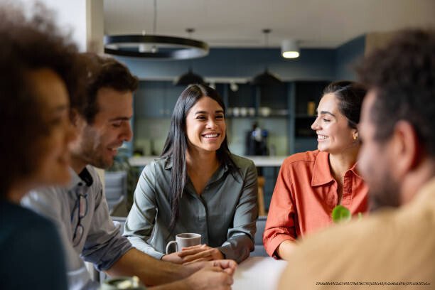 SANTÉ MENTALE AU TRAVAIL : CE QUE LES ENTREPRISES FONT SEMBLANT DE NE PAS VOIR 5 Happy Latin American businesswoman smiling in a meeting at the office