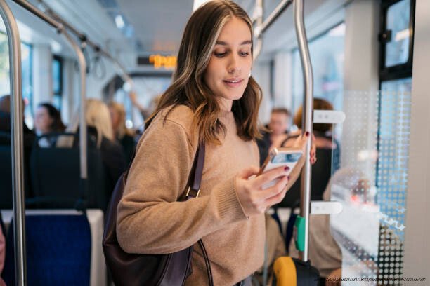 COMMENT LA COMPARAISON PERMANENTE SUR LES RÉSEAUX SOCIAUX CRÉE UNE GÉNÉRATION DÉPRIMÉE 3 Commuter using mobile phone app while traveling by bus or train
