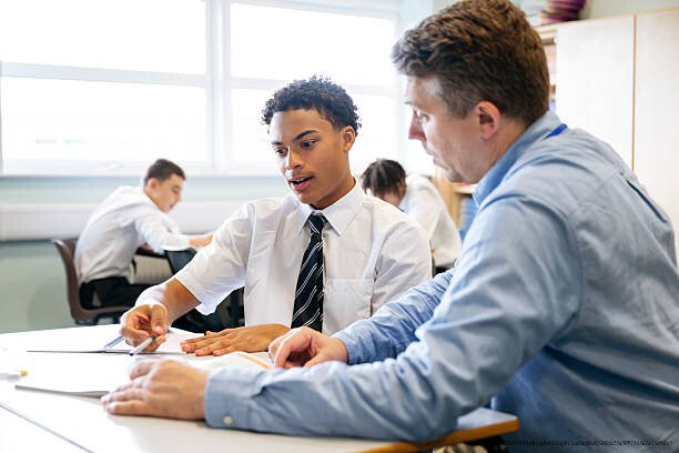 LES MÉCANISMES DE L'APPRENTISSAGE CÉRÉBRAL : DÉCOUVERTES EN NEUROSCIENCES POUR LES ENSEIGNANTS 5 Teacher and student collaborating on assignments in a modern classroom