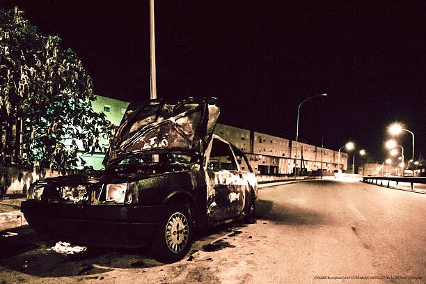 L'INFLUENCE CONTINUE DE LA MAFIA ITALIENNE SUR L'ÉCONOMIE MONDIALE 4 Burned and damaged car parked on the street in dangerous area..