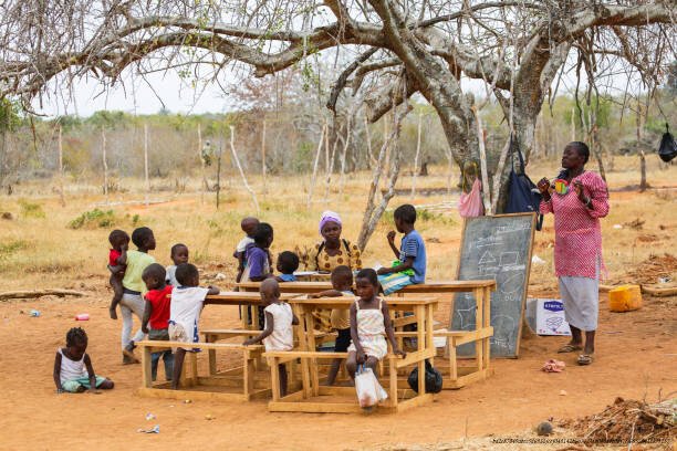 L'IMPACT DES ÉCOLES COMMUNAUTAIRES SUR LE DESTIN DES VILLAGES AFRICAINS 3 Children from small local village attending open air primary school.