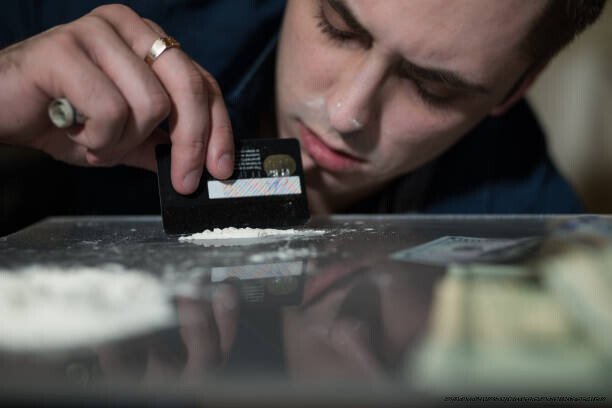 L'IMPACT DU TRAFIC DE DROGUE SUR LES GUERRES CIVILES ET LA STABILITÉ DES NATIONS 4 Addict man smells cocaine from a mirror.